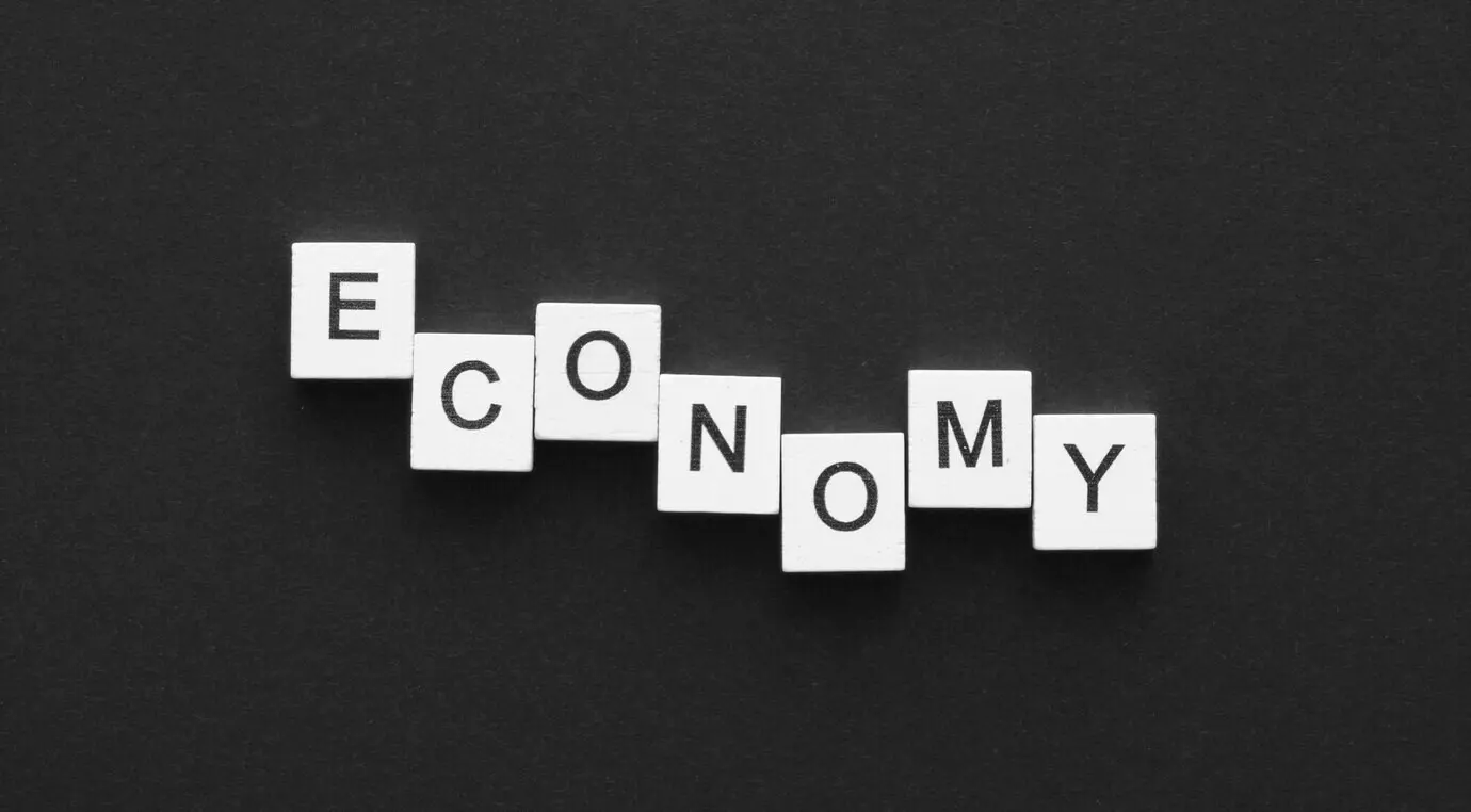 Draufsicht auf das aus Würfeln arrangierte Wort „economy“.