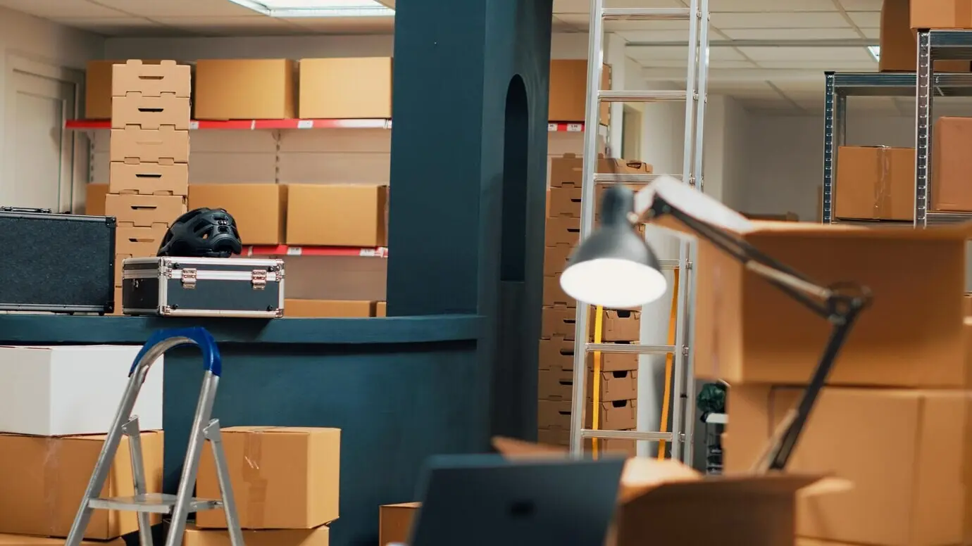 Leere Lagerfläche mit Pappkartons auf Regalen und Gestellen; Waren werden vor dem Versand an Kunden einsortiert. Lagerhalle voller Vorräte und Pakete, Großhandelsmanagement.